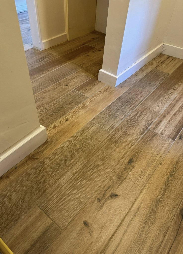 Wood-effect plank tiles flowing between rooms and doorways